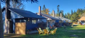 a house with chairs and a table in the yard at Riverside Resort in Qualicum Beach