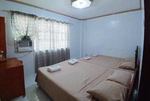 1 dormitorio con 1 cama con 2 toallas en Sinoben Apartments by RedDoorz en Santa Barbara