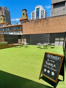 シドニーにあるザ ダウニング ホステルの芝生の看板入り公園の看板