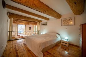 Schlafzimmer mit einem Bett und Holzboden in der Unterkunft Air-conditioned loft in the heart of the old port in Marseille