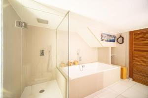 een witte badkamer met een bad en een douche bij Air-conditioned loft in the heart of the old port in Marseille