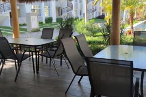 une terrasse avec des tables et des chaises ainsi qu'une piscine dans l'établissement DEPARTAMENTO con alberca, à Manzanillo