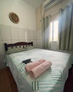 a bedroom with a bed with two towels on it at Casa Dona Vilma in Barreirinhas