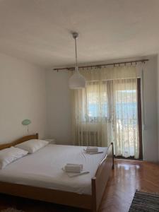 een slaapkamer met een groot bed en een groot raam bij Apartments Jere - 30 m from beach in Vinišće