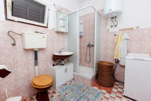 een badkamer met een wastafel, een toilet en een douche bij Apartments Jere - 30 m from beach in Vinišće