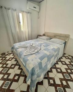 una camera con un letto e un piumone blu e bianco di Casa Dona Vilma a Barreirinhas