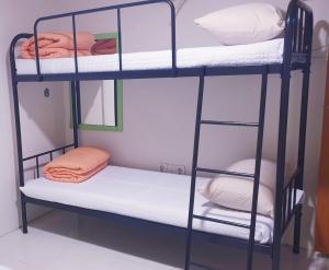 um quarto com 2 beliches com toalhas e almofadas em OPPA Hostel Sinchon-Hongdae em Seul