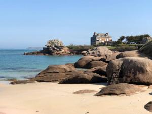 a house on the shore of a beach with rocks at Maison Trégastel, 2 pièces, 4 personnes - FR-1-368-70 in Trégastel