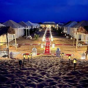 a beach at night with a path in the sand at Desert Lover's Luxury Camp in Merzouga