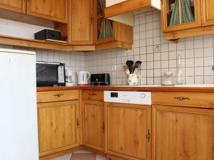 a kitchen with wooden cabinets and a counter top at Maison proche centre de St Pierre, 6 couchages, cour ensoleillée, à 20 min de la mer à vélo. - FR-1-246A-83 in Saint-Pierre-dʼOléron +8 photos