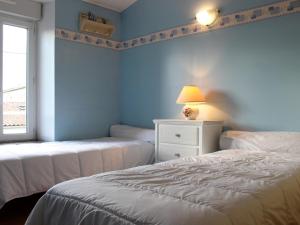 two beds in a room with blue walls and a window at Maison proche centre de St Pierre, 6 couchages, cour ensoleillée, à 20 min de la mer à vélo. - FR-1-246A-83 in Saint-Pierre-dʼOléron