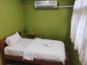 a green bedroom with a bed and a air conditioner at Airport one station hometel - Suvarnabhumi - SHA Extra Plus in Bangkok