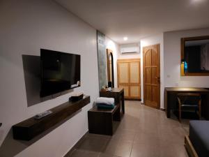 a living room with a flat screen tv on a wall at La Collina Villa in Jepara