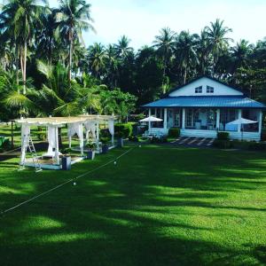 una casa con un patio de césped con un edificio en Kehalani Beach Resort by Cocotel en Quezon