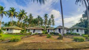 una fila de casas frente a palmeras en Kehalani Beach Resort by Cocotel en Quezon