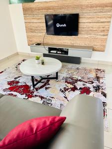 a living room with a couch and a table and a tv at EVO Soho Suites Duplex Homestay in Bandar Baru Bangi