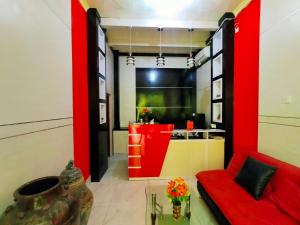 a living room with a red couch and a kitchen at Inawa Homestay Syariah in Rampal