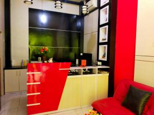 a living room with a red counter and a red chair at Inawa Homestay Syariah in Rampal