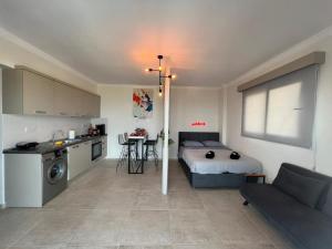 a bedroom with a bed and a kitchen with a table at Amazing seaview studio with pool-steps away beach in Áyios Yeórgios