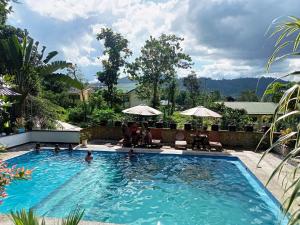 a large swimming pool with people in the water at Dheltor Hilltop in San Vicente