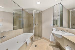La salle de bains est pourvue d'une baignoire, d'un lavabo et d'une douche. dans l'établissement Crowne Plaza Surfers Paradise, an IHG Hotel, à Gold Coast
