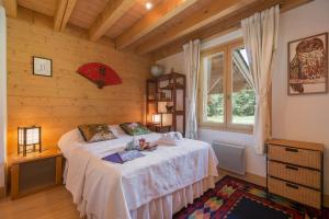 ein Schlafzimmer mit einem Bett in einem Zimmer mit einem Fenster in der Unterkunft Chalets d'en haut - Zaria - Happy Rentals in Argentières