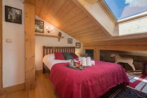 ein Schlafzimmer mit einem Bett mit einer roten Decke in der Unterkunft Chalets d'en haut - Zaria - Happy Rentals in Argentières
