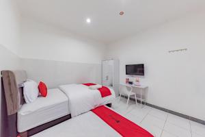 een witte slaapkamer met een bed en een rood tapijt bij RedDoorz Syariah near Alun Alun Ciledug Cirebon in Cirebon