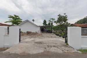 Uma casa branca com uma entrada à frente. em RedDoorz Syariah near Alun Alun Ciledug Cirebon em Cirebon