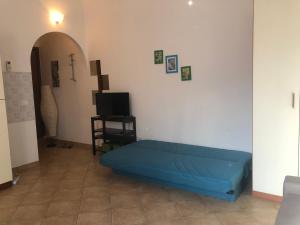 a blue couch in a living room with a tv at Liana monolocale in San Vincenzo