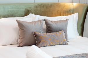 un grupo de almohadas sentado encima de una cama en VIZUALIZA Residence Hotel, en Plovdiv