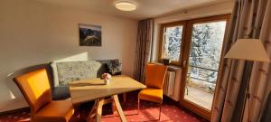 um quarto com uma mesa e cadeiras e uma janela em Berghof Mehlan em Fischen