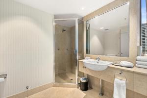 uma casa de banho com um lavatório e um chuveiro em Crowne Plaza Surfers Paradise, an IHG Hotel em Gold Coast