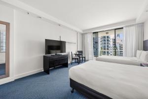 a hotel room with a bed and a flat screen tv at Crowne Plaza Surfers Paradise, an IHG Hotel in Gold Coast