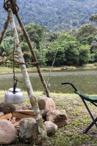 a bird standing on top of rocks next to a river at Sahom Valley Resort - Agro & Eco Park in Kampar