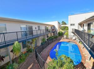 an apartment patio with a swimming pool in front of a building at Crystal Waters 7 in Bargara