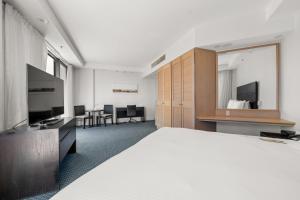 Habitación de hotel con cama grande y TV en Crowne Plaza Surfers Paradise, an IHG Hotel en Gold Coast