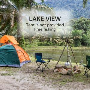 a tent and chairs in front of a lake view at Sahom Valley Resort - Agro & Eco Park in Kampar