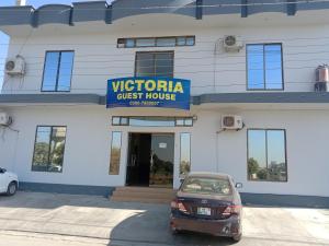 Victoria Guest House في بهاوالبور: سيارة متوقفة أمام بيت ضيافة