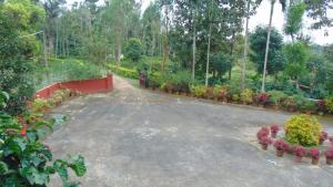 a driveway in a garden with flowers and plants at Shree Raksha Homestay in Gonikoppal
