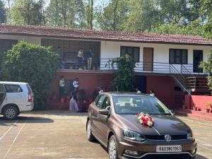 a car parked in a parking lot in front of a house at Shree Raksha Homestay in Gonikoppal