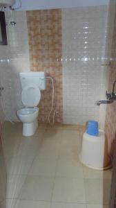 a bathroom with a toilet and a blue bucket in it at Shree Raksha Homestay in Gonikoppal