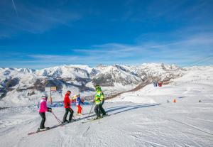 a group of people skiing down a snow covered mountain at Stella Alpina - Happy Rentals in Livigno