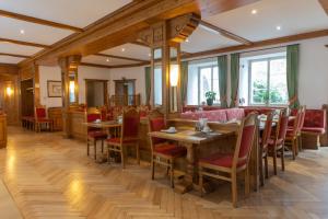 a restaurant with wooden tables and red chairs at Hotel Gasthof Stift in Lindau