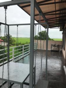 a porch with swings and a view of a field at Bendang Homes - Sekinchan Homestay in Kampong Sungai Leman +2 photos