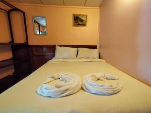ein Bett mit zwei weißen Handtüchern darauf in der Unterkunft SSP Bungalow in Trat