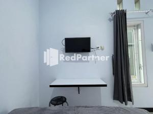 a bedroom with a bed and a desk and a window at N3 Syariah near Stasiun Tegal Mitra RedDoorz in Tegal