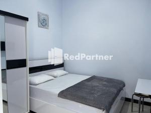 Un dormitorio con una cama con un letrero de socio rojo. en N3 Syariah near Stasiun Tegal Mitra RedDoorz en Tegal