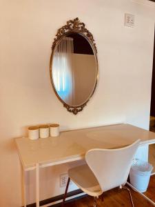 a mirror on a wall with a desk and a chair at Cellar In Town in Robertson