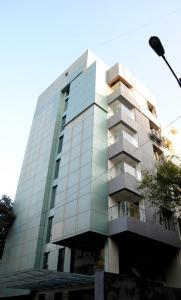 a tall glass building with a balcony at Quality Inn Mint in Pune